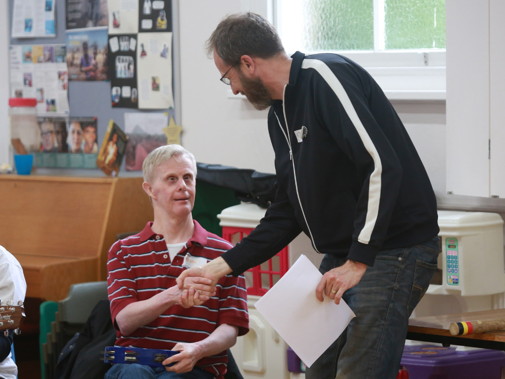 Stephen takes a moment to connect personally with a Rich Tea attendee, a handshake a tangible expression of care and shared community.